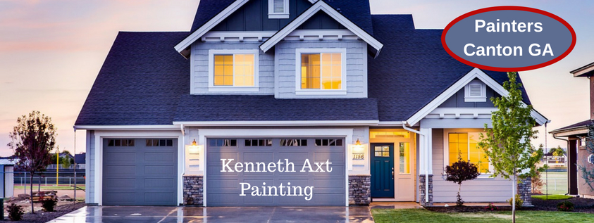 blue craftsman home at dusk with lights on inside | Painters Canton GA in blue oval outlined in red in upper riht | Kenneth Axt Painting watermark across garage door